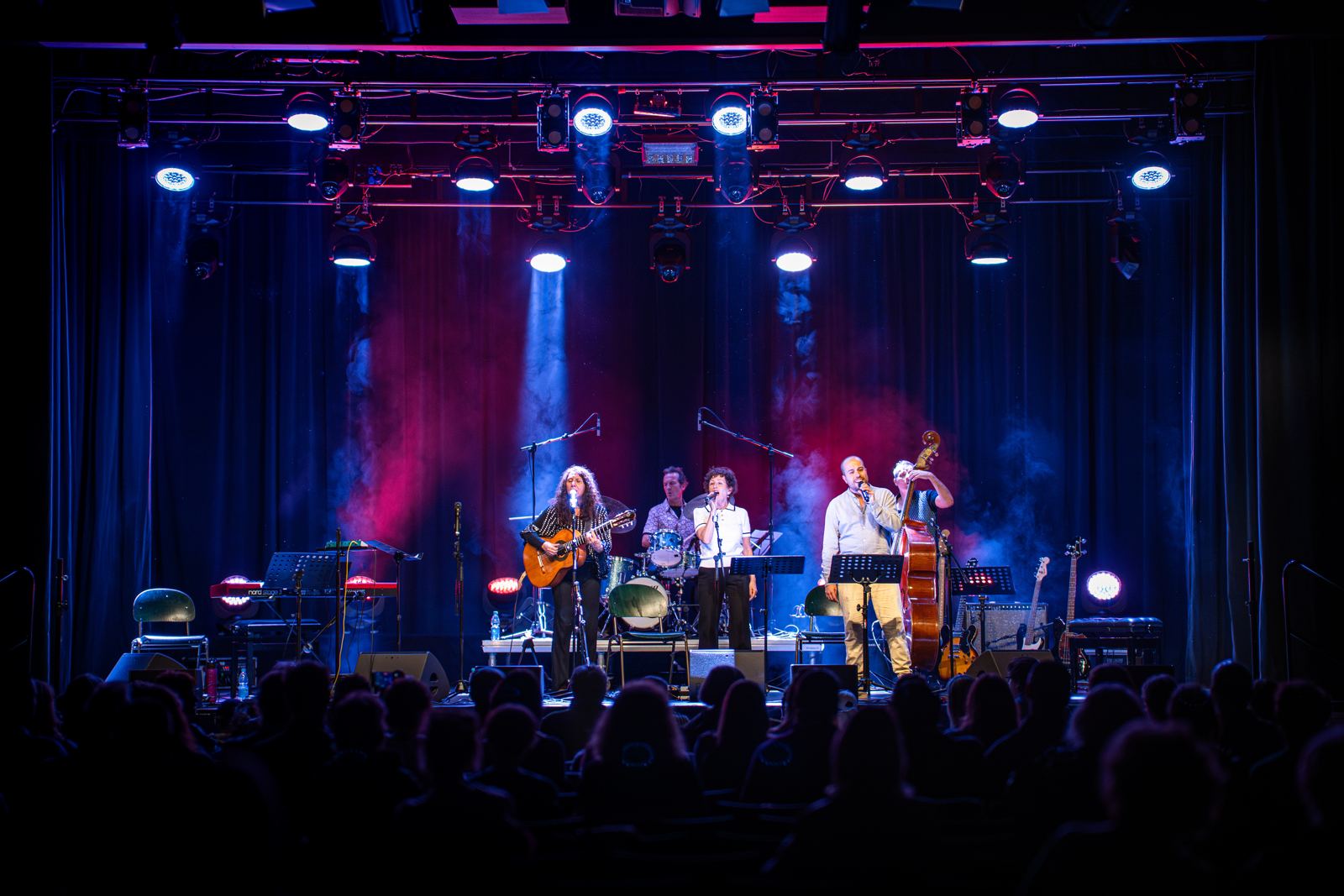 Konzert mit Band auf großer Bühne in blauem und rotem Licht